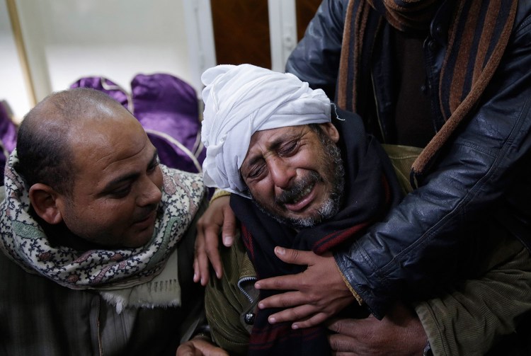 A man is comforted by others as he mourns over Egyptian Coptic Christians who were captured in Libya and killed by militants affiliated with the Islamic State group, outside of the Virgin Mary church in the village of el-Aour, near Minya, 135 miles south of Cairo, Egypt.