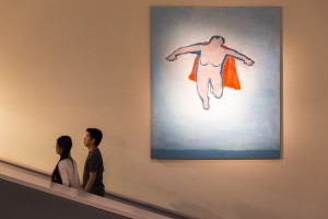 Chicagoans Angel Wuang and Chris Lam walk past “Woman Flying,” a painting by Katherine Bradford, as they acsend from the lower level of the Portland Museum of Art. The museum’s “Directors’ Cut,” a collaborative summer exhibition of works from institutions across the state, continues through Sept. 20. Ben McCanna/Staff Photographer