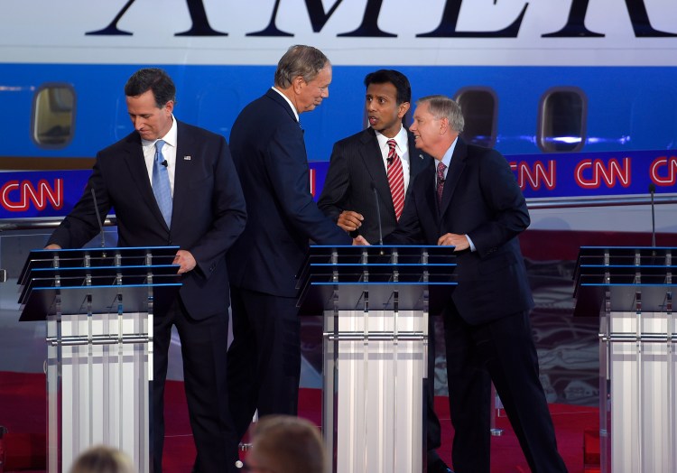 Republican presidential candidates Rick Santorum, left, George Pataki, second from left, Bobby Jindal, second from right, and Lindsey Graham talk at the finish of their debate Wednesday night.
The Associated Press