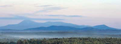 Early morning haze colors Mount Katahdin and its surrounding mountains on a July day, seen from a height of land along Route 11 in Patten. Gregory Rec/Staff Photographer