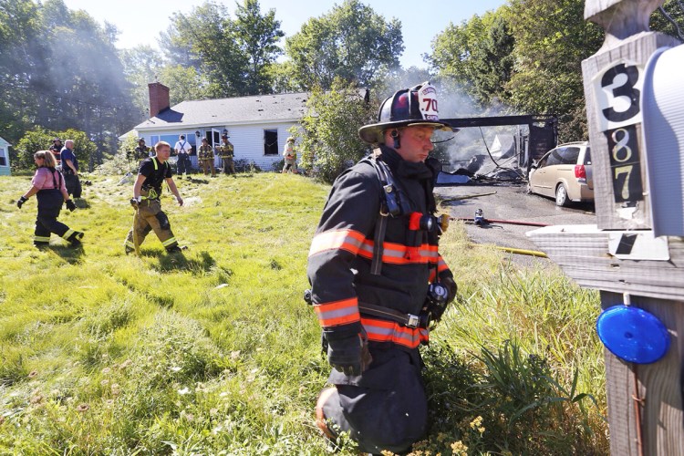 Firefighters work at the scene of a house fire Wednesday that started in the garage at 387 South St. in Biddeford. One person was home and safely out of the house when emergency responders arrived, according to acting Fire Chief Scott Gagne. Derek Davis/Staff Photographer

