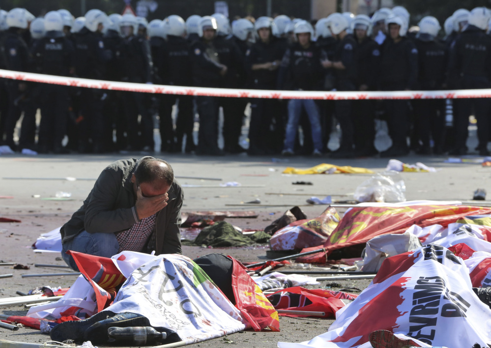 A man cries over the body of a victim at the site of an explosion in Ankara, Turkey, Saturday. The Associated Press