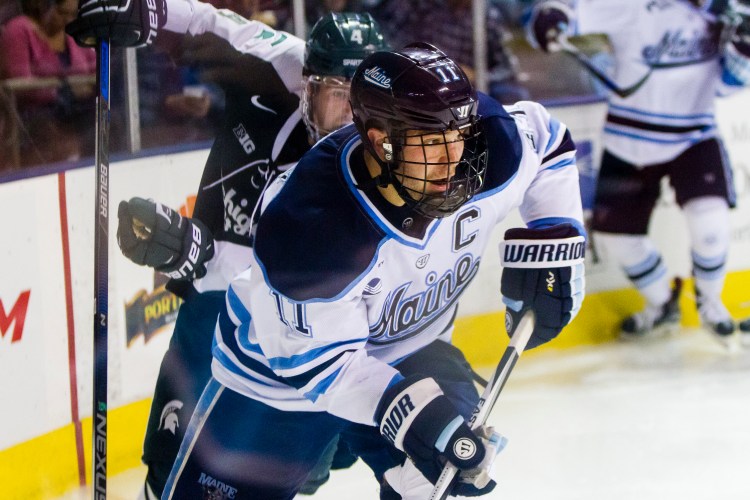 Maine senior Steven Swavely looks for an opening in the second period against Michigan State at Cross Insurance Arena. He scored in a shootout to give Maine a 4-3 win in the Ice Breaker tournament. Ben McCanna/Staff Photographer