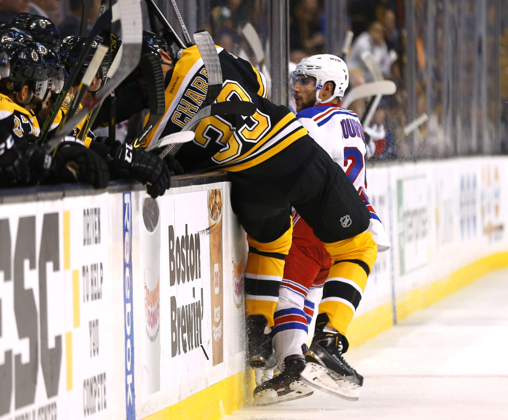 Boston Bruins defenseman Zdeno Chara is checked into the boards by New York Rangers’ Ryan Bourque during the first period of a preseason game in Boston on Sept. 24. Chara was injured on the play and left the game. The Bruins hope he will be ready for the regular-season opener Oct. 8.