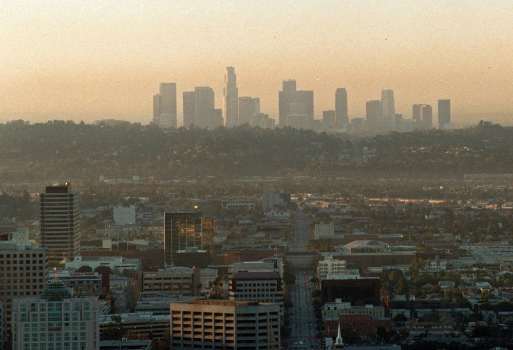Two downtowns, Glendale, Calif., in the foreground and Los Angeles in the background, are seen just after sunrise  as a low, brown haze covers the area.  Environmentalists say that new EPA standards fall far short of what public health experts had recommended.