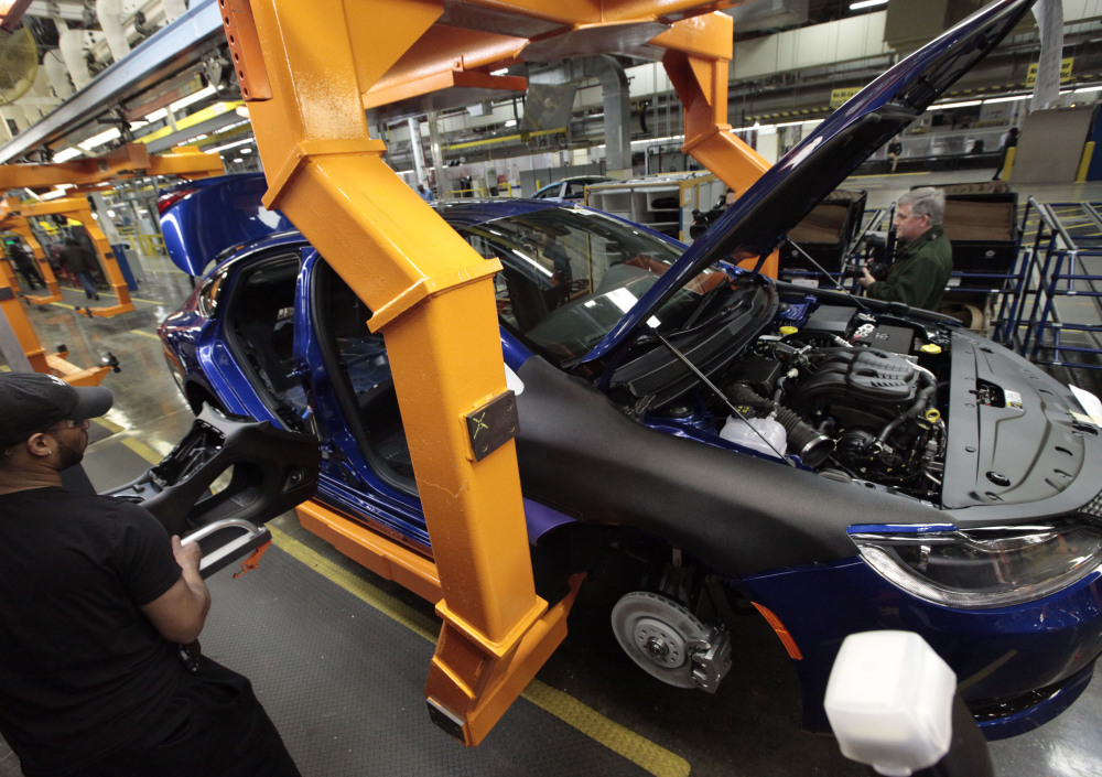 An assembly line worker builds a 2015 Chrysler 200 at the plant in Sterling Heights, Mich. Fiat Chrysler’s U.S. sales jumped nearly 14 percent in September, helped by the automaker’s Jeep brand. Fiat Chrysler’s factory workers rejected a proposed contract Thursday, however.
