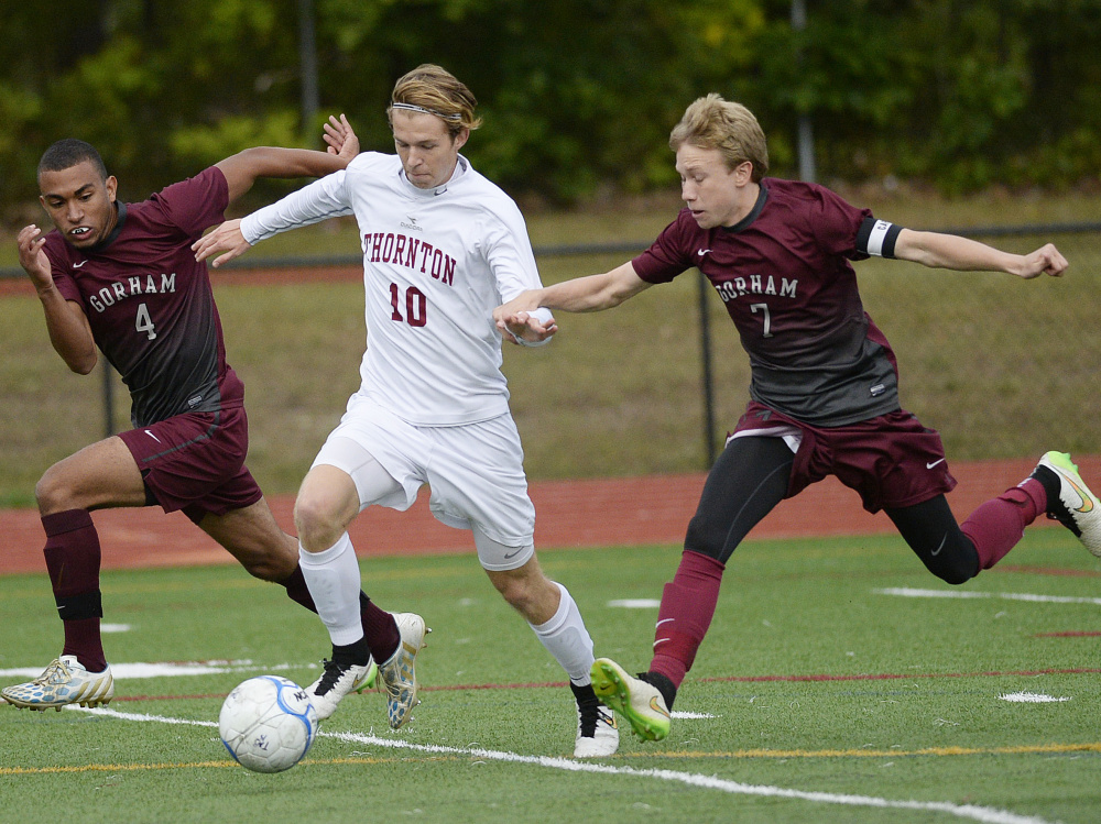 Simon Trcka, who scored three goals for Thornton Academy, looks to break in while defended by Emerson Fox, left, and Jackson Taylor of Gorham. Trcka scored his first goal on the play.