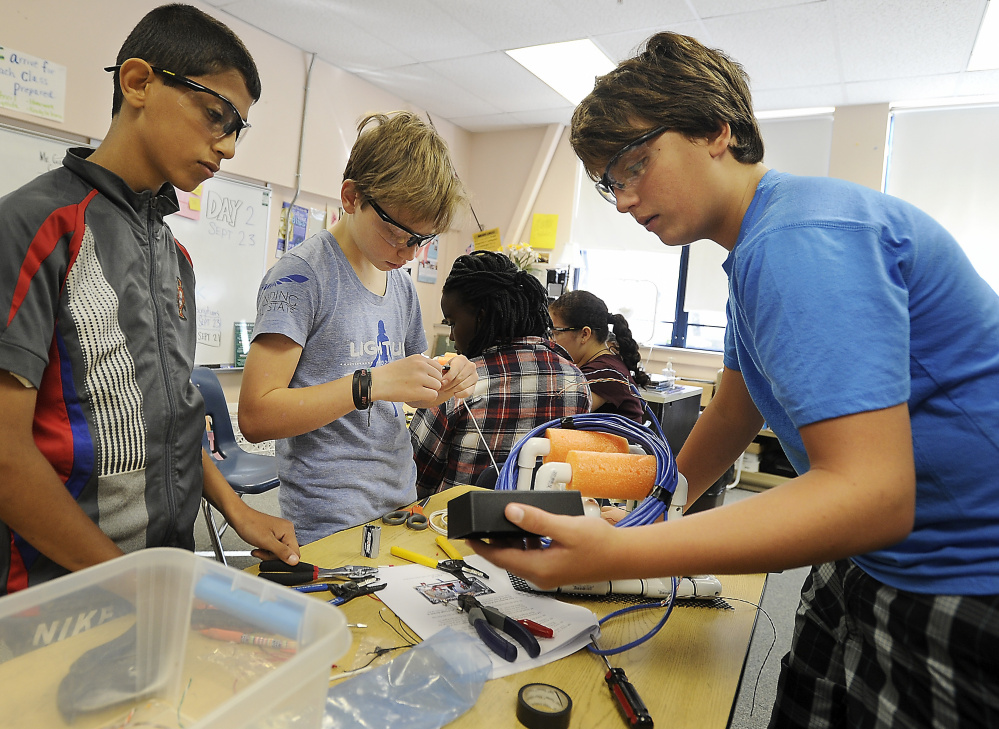 King Middle School students Ameer Alasadi, 12, Evan Haapala, 12, and Josh Willey, 13, at work building submersible devices for scientific research.