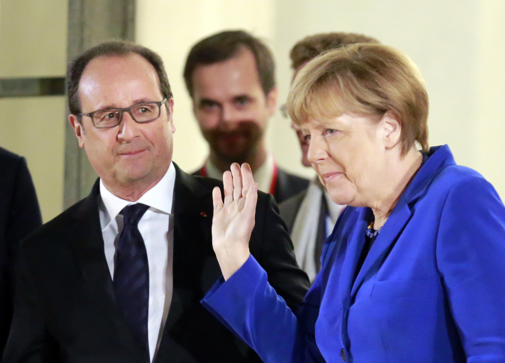 German Chancellor Angela Merkel leaves the Elysee Palace in Paris, France, after a meeting Friday with French President Francois Hollande, left, on the prospects for peace in Ukraine.