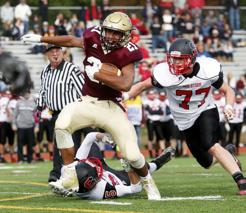 Greg Ruff, who gained 227 yards on 30 carries for Thornton Academy, tries to avoid Mahlon Glidden, right, and Connor Kelly of Scarborough during the first quarter of Thornton’s 48-7 victory Saturday.