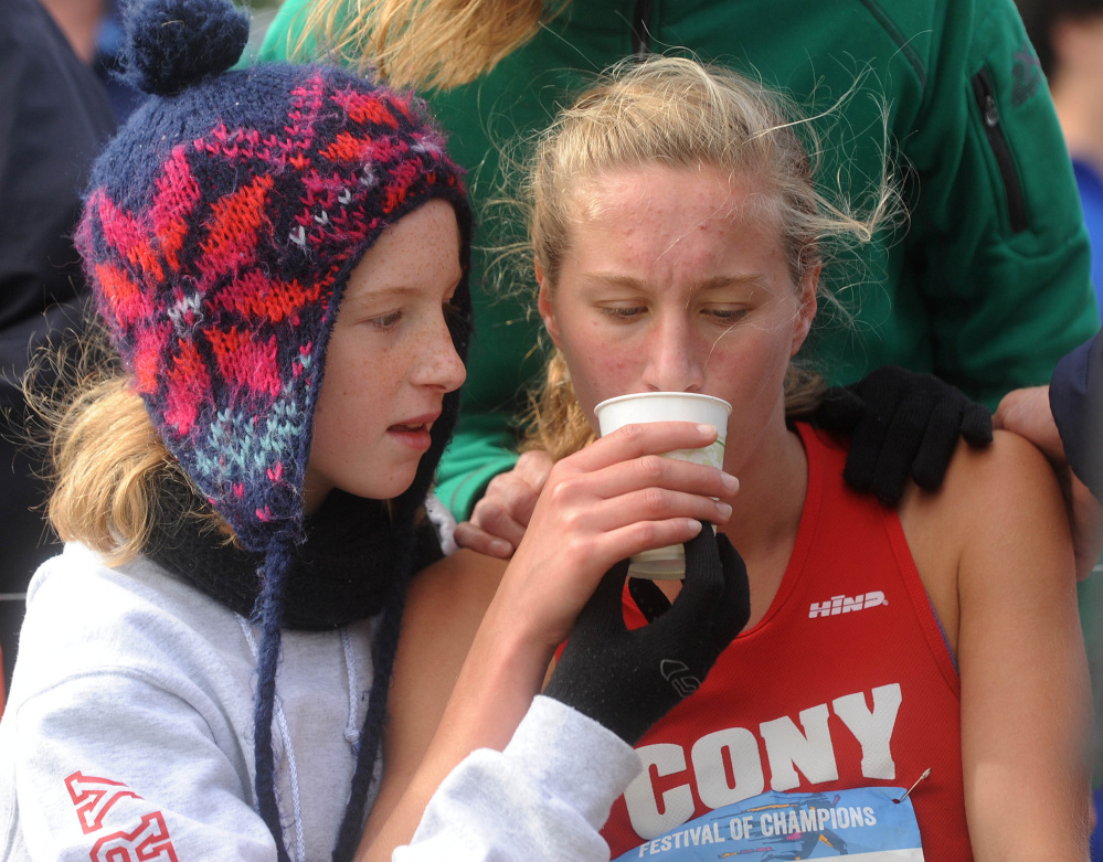 Anne Guadalupi of Cony High in Augusta drinks some water after finishing her race.