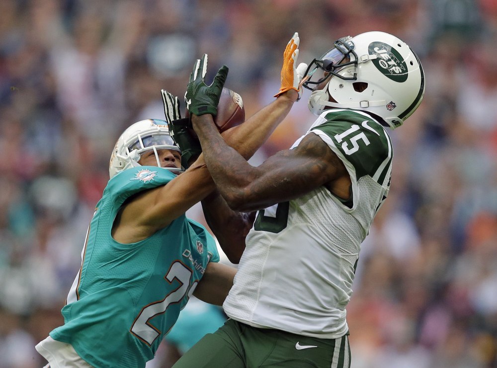 New York Jets’ Brandon Marshall, right, catches the ball during Sunday’s game in London.