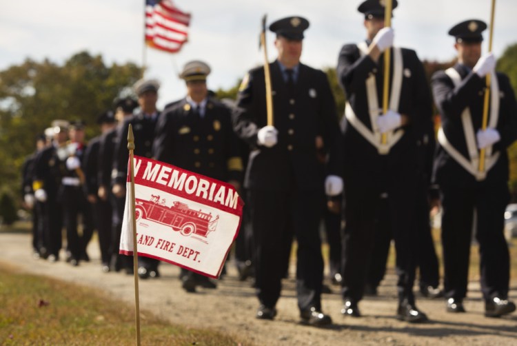 Portland and South Portland fire department members march toward the Portland Veteran Firemen’s Association monument during the annual Memorial Sunday Service at Forest City Cemetery in South Portland on Sunday.