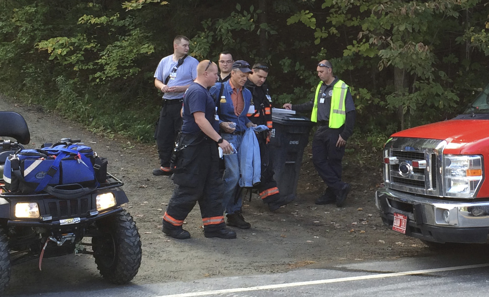 Emergency first responders assist a man, center, as he is transferred to an ambulance from a trailer attached to an all-terrain vehicle near the site of an Amtrak train derailment Monday in Roxbury, Vt.