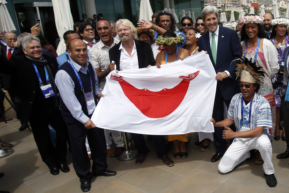 Virgin Group founder Richard Branson, center left, holds the Easter Island flag with U.S. Secretary of State John Kerry on the sidelines of the Our Ocean international conference on marine protection in Vina del Mar, Chile, on Monday.