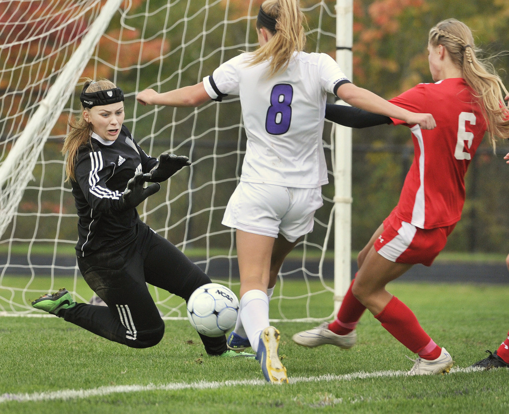 Sanford goalie Kyla Bragg makes a save on a shot by Marshwood’s Reagan Nichols, center, while Sanford’s Megan O’Connell defends during the Hawks’ 3-1 win in a Class A South girls’ soccer game Monday in South Berwick.