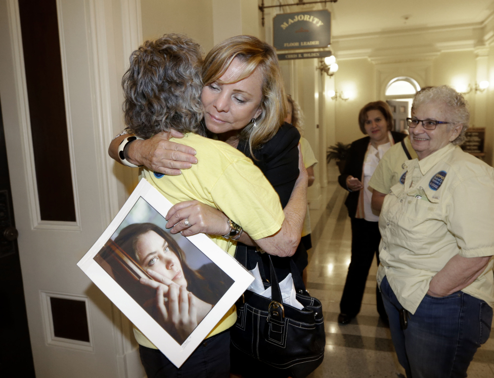 Debbie Ziegler holds a photo of her late daughter, Brittany Maynard, as she receives congratulations following the announcement that California would be the fifth state with a right-to-die law. Maynard, who had brain cancer, moved to Oregon to end her life.