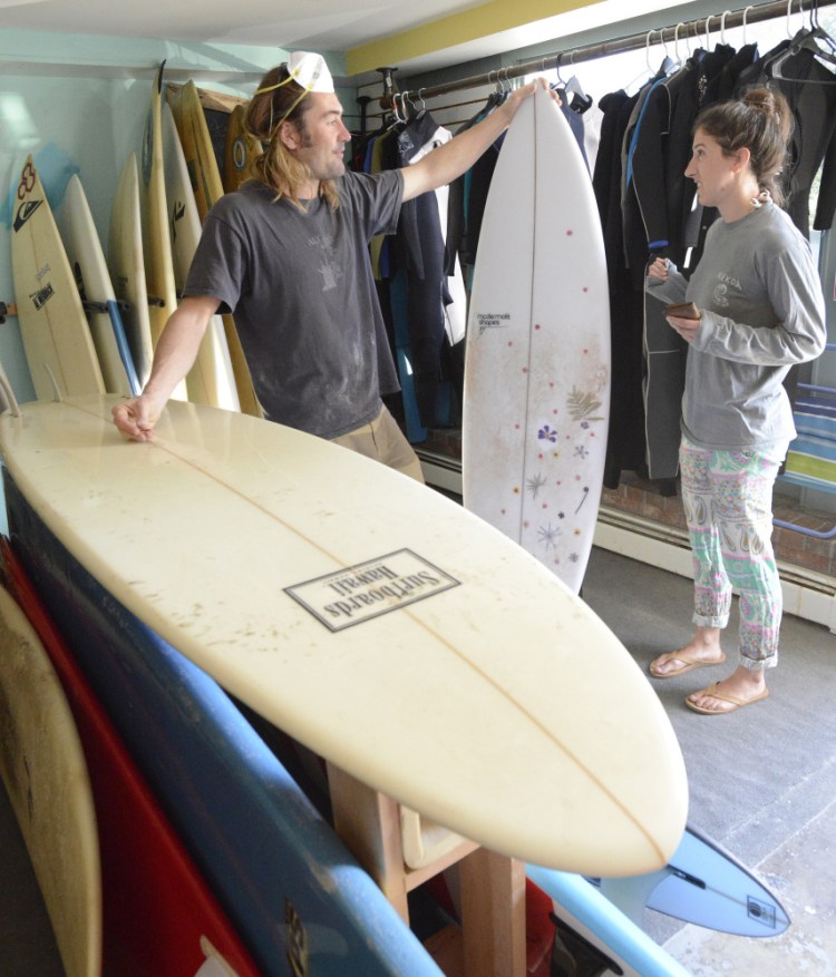 Andy McDermott talks with customer Margot Levy of Portland, whose custom surfboard was in the shop for a ding repair.
Shawn Patrick Ouellette/Staff Photographer