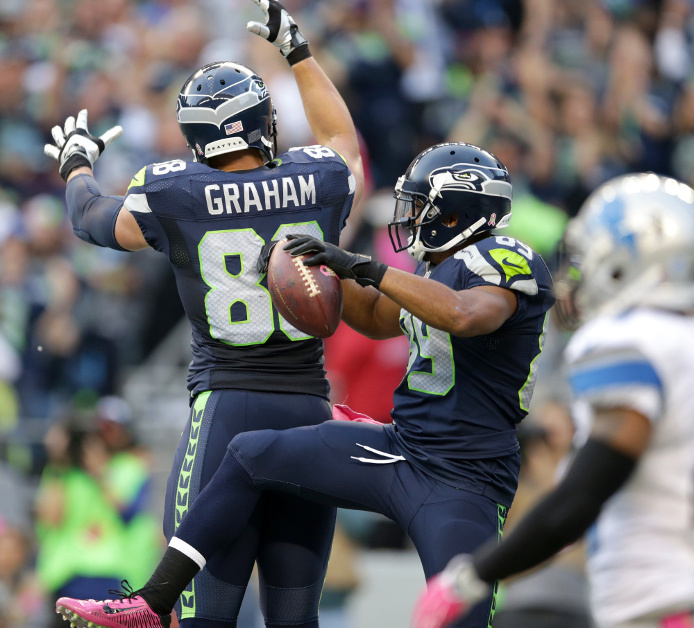 Seattle wide receiver Doug Baldwin, center, celebrates with teammate Jimmy Graham after Baldwin scored a touchdown in the first half Monday against Detroit in Seattle. The Seahawks won, 13-10.