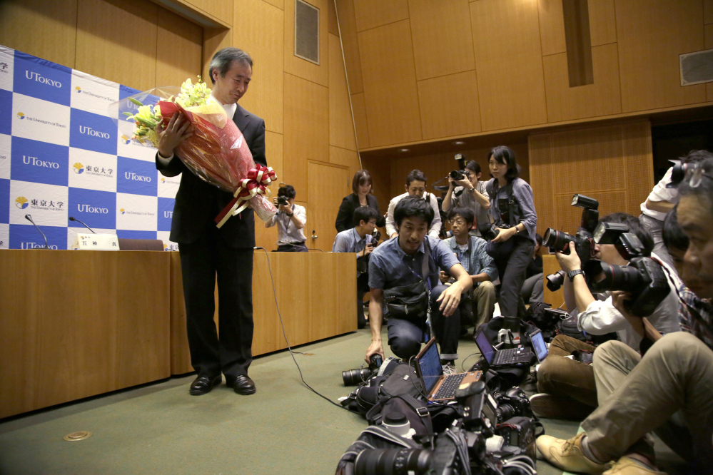 Takaaki Kajita of Japan receives flowers during a news conference Tuesday in Tokyo.