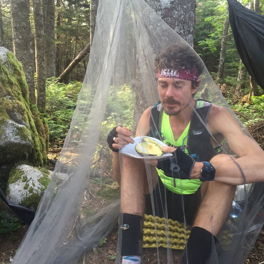 Scott Jurek snacks on avocados while in the Mahoosuc Range near the New Hampshire-Maine border. His wife and friends hiked 3 miles to bring him the treat.