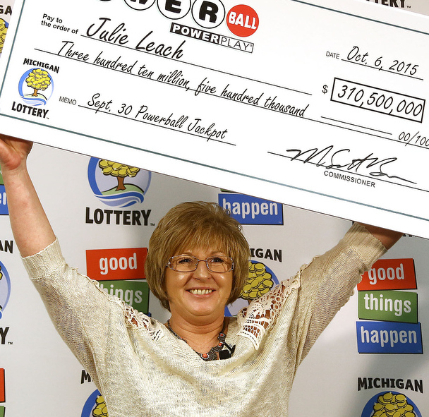 Powerball winner Julie Leach holds a ceremonial check for $310.5 million Tuesday.