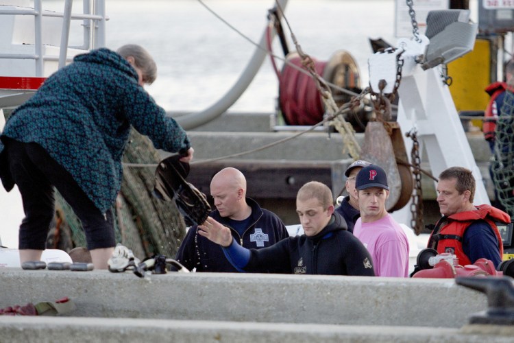 Members of the dive team hand up their gear after recovering the body of Dennis McGrath near the Portland Fish Pier on Wednesday.