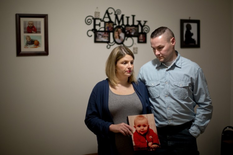 Jon and Beth Guay hold a photo of their son, Colton, on Wednesday at their home in Poland. Colton died Monday of complications from a disease caused by E. coli bacteria, which his family thinks he contracted by touching animals at the Oxford County Fair’s petting zoo last month.