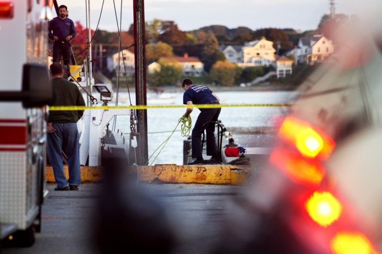 U.S. Coast Guard officials and other emergency personnel look for a diver Wednesday after he failed to surface while working under a fishing vessel at the Portland Fish Pier.