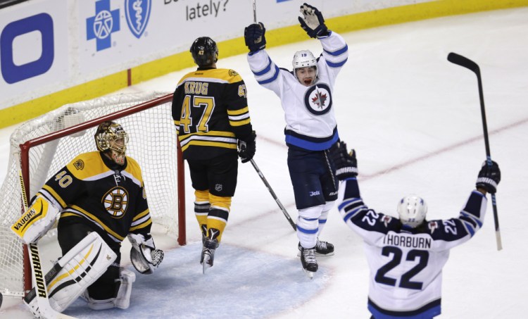 Winnipeg Jets center Nicolas Petan, second from right, celebrates with teammate Chris Thorburn (22) after his goal against Bruins goalie Tuukka Rask in the third period of Thursday night’s game in Boston.