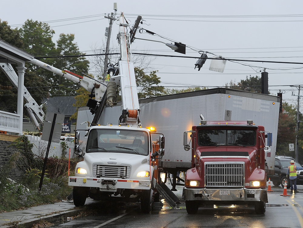 PORTLAND, ME - OCTOBER 9: Truck accident at corner of Brighton and Stevens Avenues. Workers prepare to remove the utility pole snapped off by the truck, right, on a sharp turn.(Photo by)