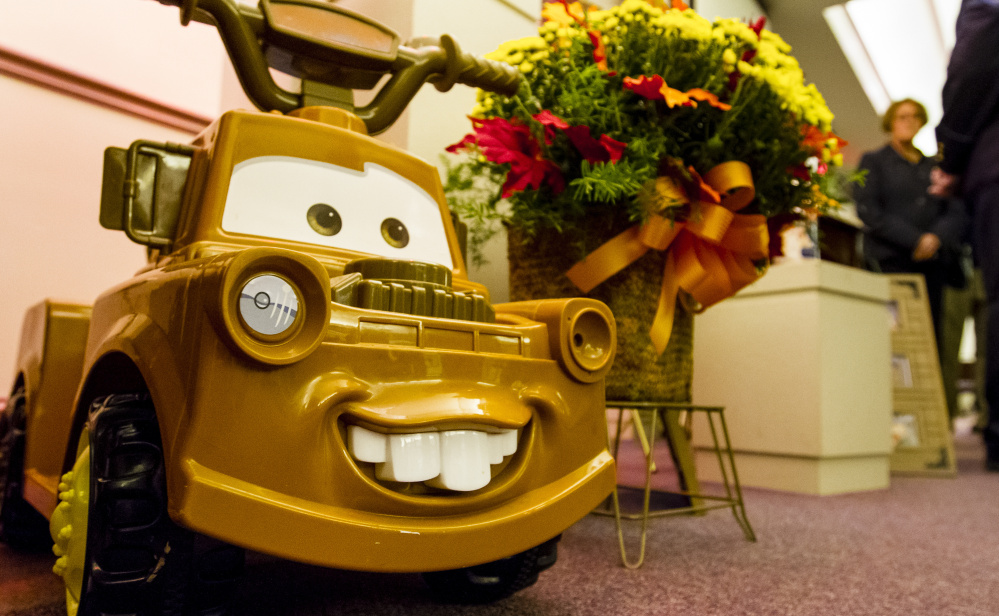 Toys, including this ride-on truck, were interspersed with more than a dozen flower arrangements at Fortin Funeral Home during a public wake Friday in Auburn in memory of Colton Guay, a 20-month-old boy who died after exposure to E. coli.