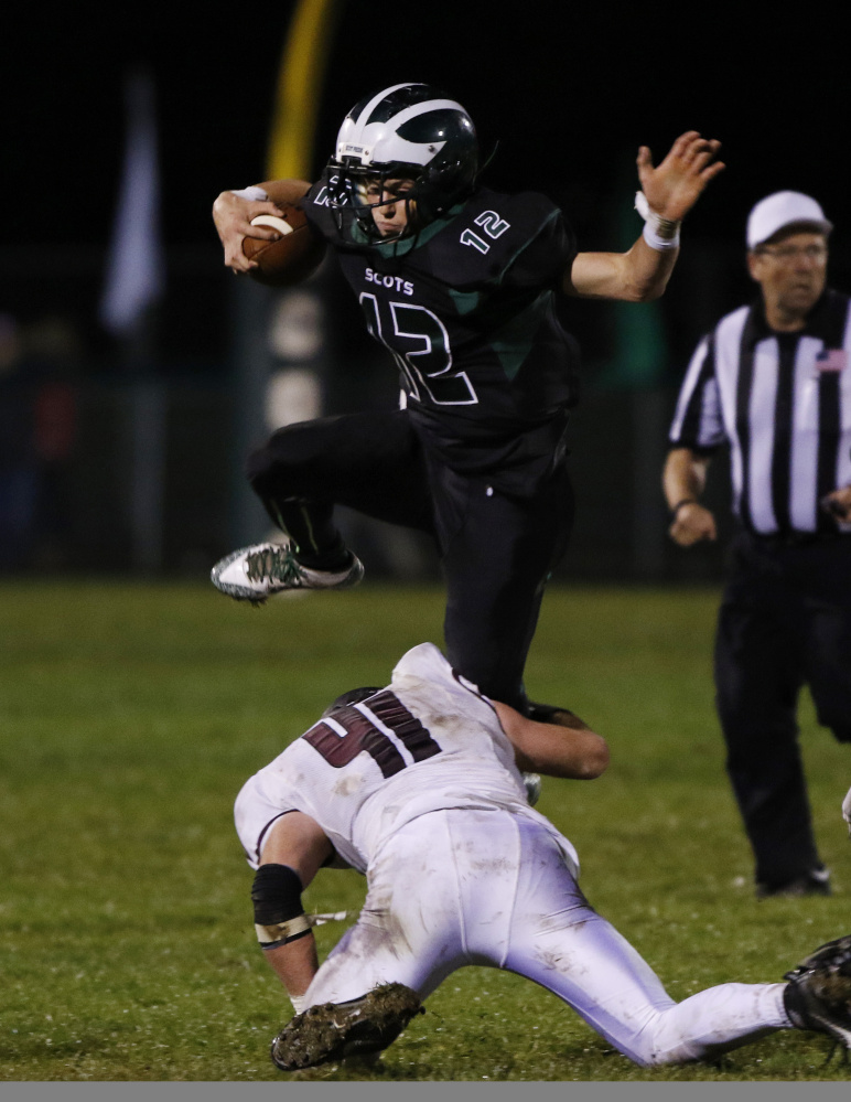 Bonny Eagle quarterback Cam Day jumps over Windham’s Patrick Leavitt during the third quarter of their game in Standish on Friday night. Day helped lead the Scots to a 33-13 win. Joel Page/Staff Photographer