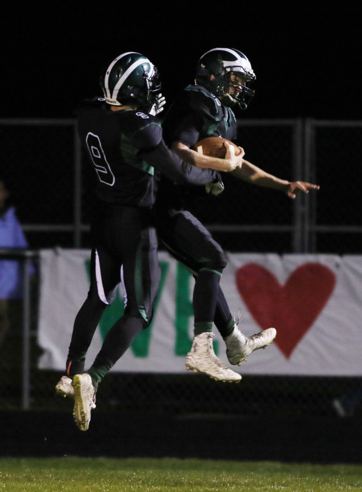 Bonny Eagle’s Ben Autry, left, celebrates with Eben Cram in the second quarter following the first of Cram’s two receiving touchdowns Friday night in a 33-13 win over Windham at Standish. Joel Page/Staff Photographer