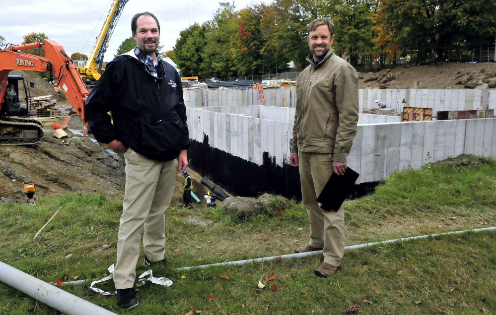 Jeff McKay, left, director of facilities management at the University of Maine at Farmington, and Luke Kellett, coordinator of the Sustainable Campus Coalition, outside the biomass central heating plant construction.