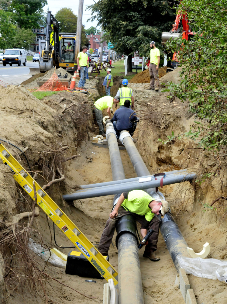 Workers lay pipes for the biomass heating system along Main Street near the University of Maine at Farmington.