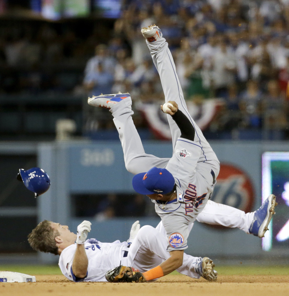 Mets shortstop Ruben Tejada goes over the top of Dodgers second baseman Chase Utley in the seventh inning Saturday. Tejada broke his leg on the play.