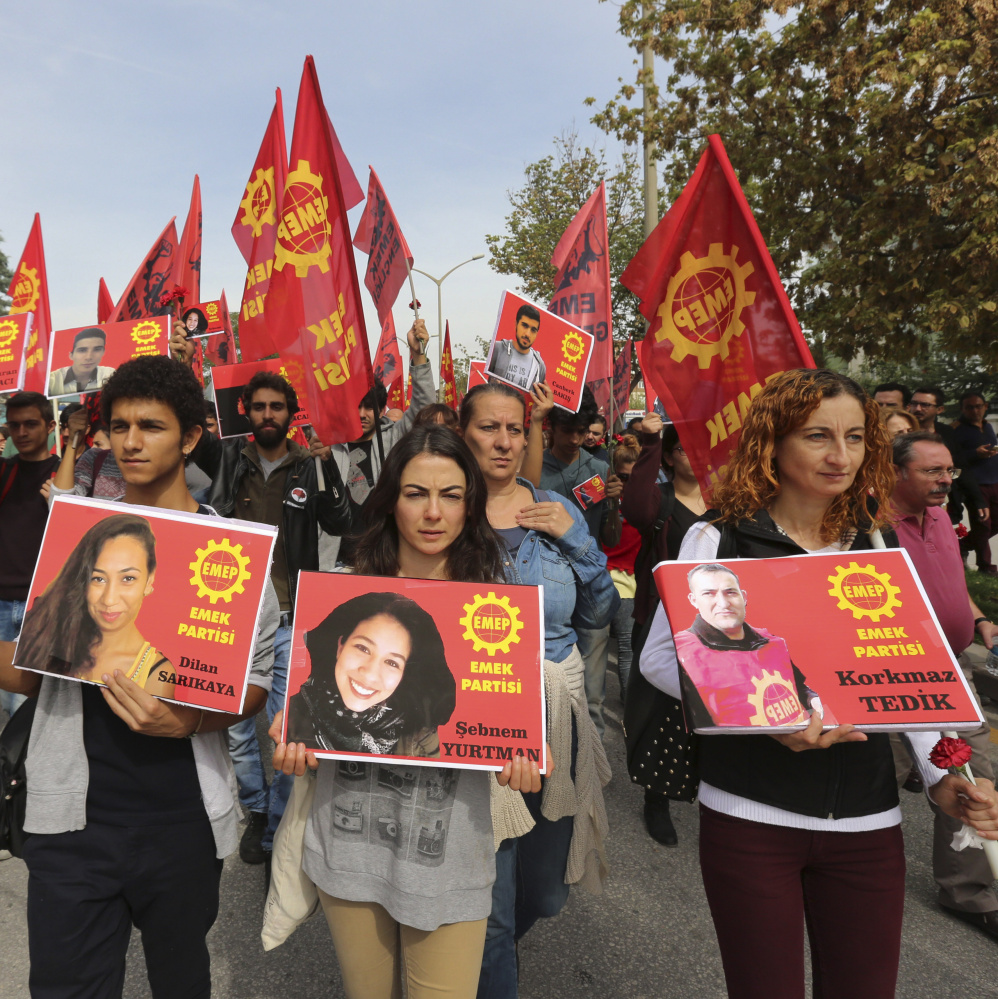 Protesters carry pictures of people killed in Saturday’s bombing attack during a march in Ankara, Turkey, on Sunday. Turkey declared three days of mourning following Saturday’s nearly simultaneous explosions that targeted a peace rally in Ankara.