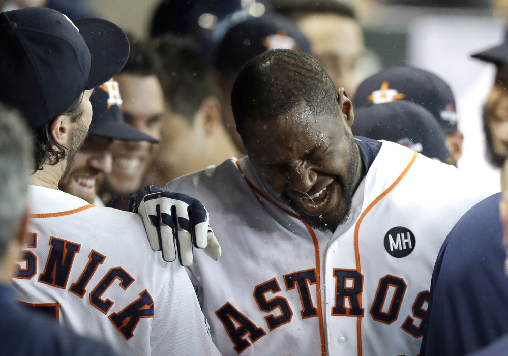 Teammates splash water on Houston Astros' Chris Carter in the dugout after he hit a home run against the Kansas City Royals in the seventh inning in Game 3 of the American League Division Series on Sunday in Houston. The Associated Press