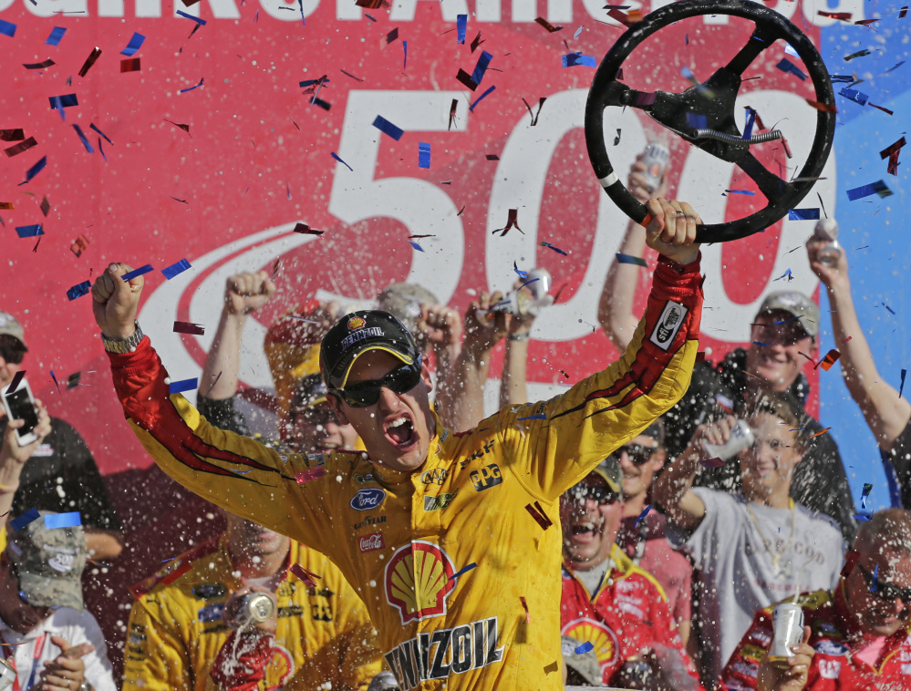 Joey Logano celebrates after earning his fourth Sprint Cup win of the season Sunday at Charlotte Motor Speedway. Logano led 227 of 334 laps, and is assured of being one of the final eight drivers in the playoffs.