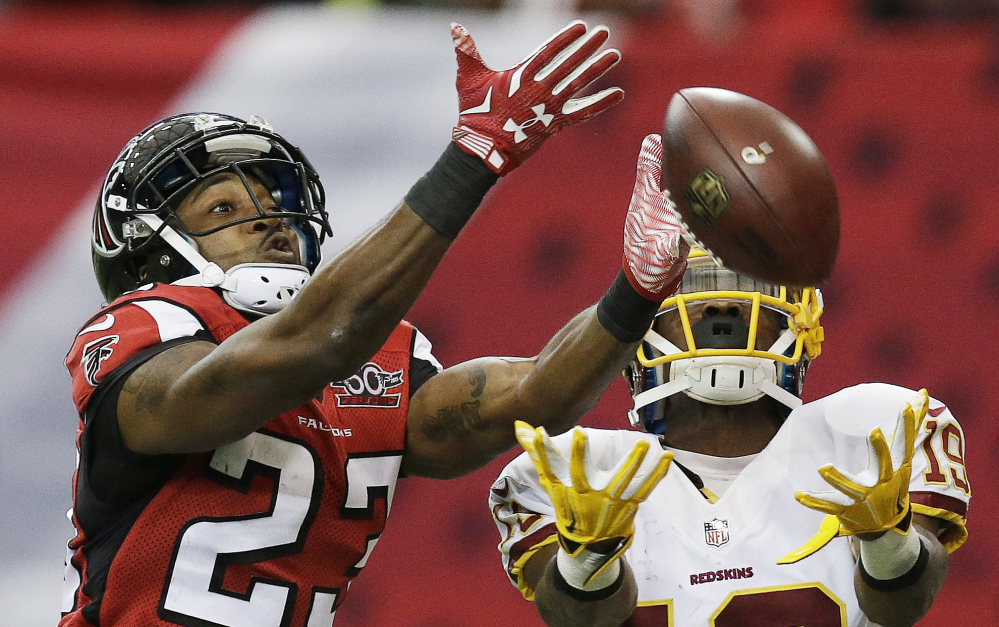Falcons cornerback Robert Alford, left, breaks up a pass intended for Washington’s Rashad Ross. Alford later intercepted a pass and returned it for the winning touchdown in overtime.