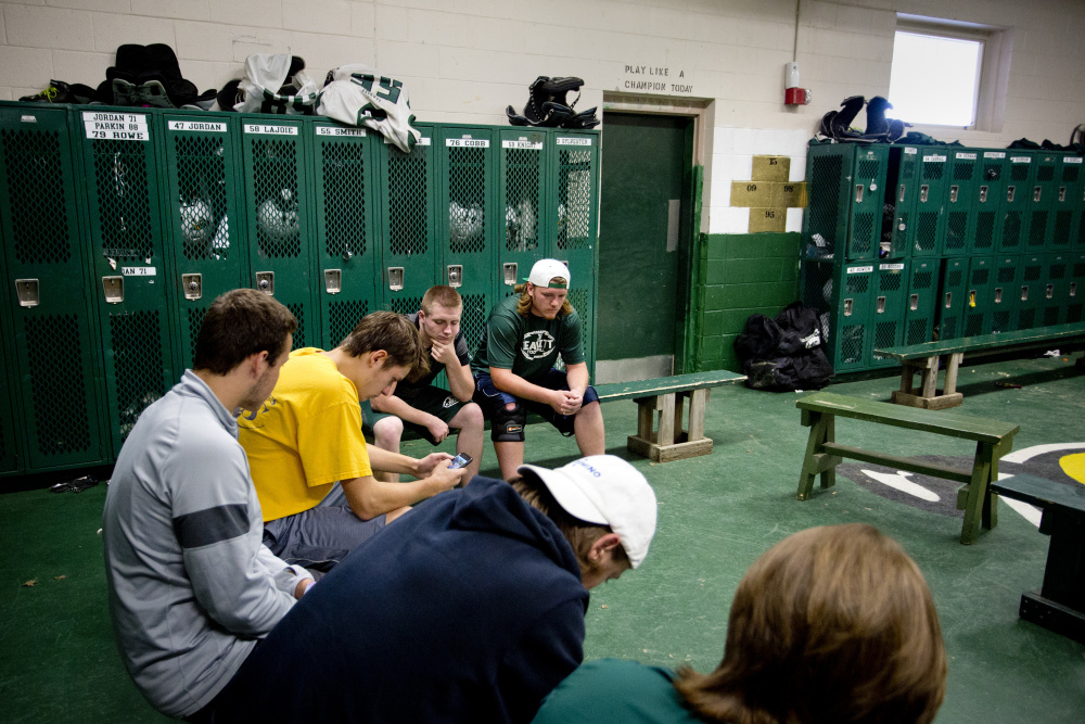Members of the Leavitt Area High School football team sit quietly in their locker room in Turner before practice Monday as the conversation shifted to teammate Adam Smith, who suffered a severe spleen injury on Saturday. “I can’t even believe this is real,” said senior defensive lineman Gage Jordan, center, with hand on his chin.