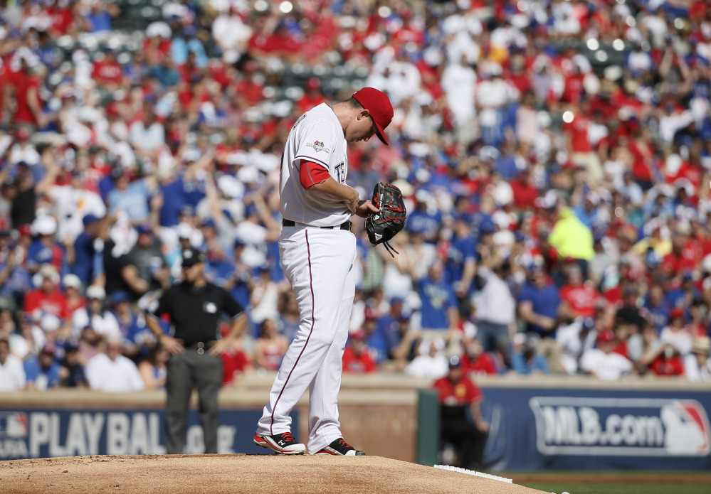 Rangers starting pitcher Derek Holland pauses after Josh Donaldson’s home run. Holland lasted just two innings, giving up six runs on five hits.