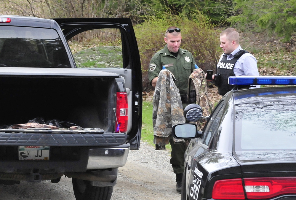 Game warden Dave Ross, left, and Winslow Police Detective Ryan McGowen look over turkey hunting gear belonging to Janice and Reginald Jacques on May 5 after Janice Jacques accidentally shot her husband while turkey hunting. Janice Jacques pleaded guilty to a misdemeanor charge last month.
