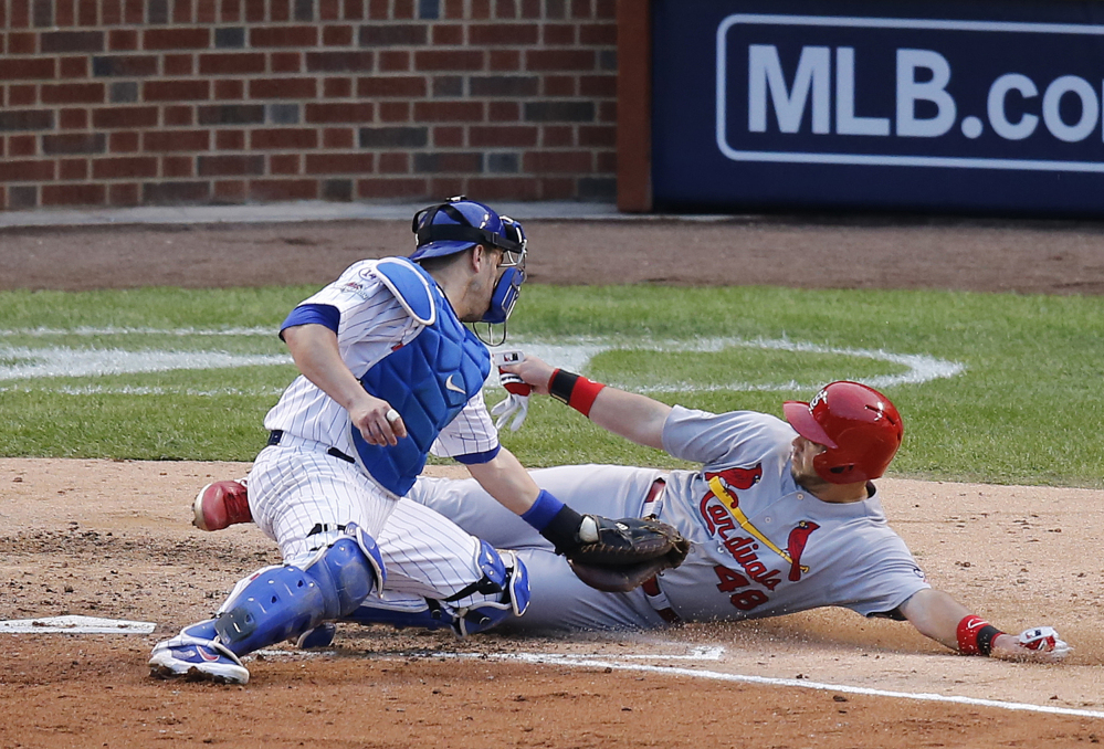 Cubs catcher Miguel Montero tags out the Cardinals’ Tony Cruz on a play in the sixth inning. The Cubs got out of the inning in a 4-4 tie and took the lead in the bottom half of the inning.