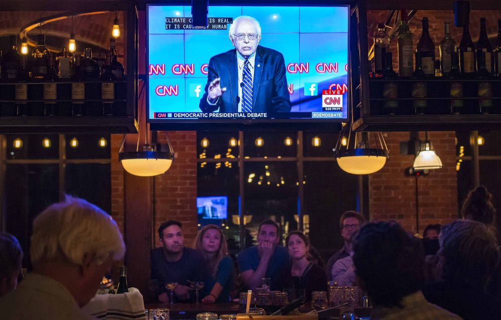 People watch the Democratic presidential debate from Las Vegas at a restaurant in Winooski, Vt. The Vermont Democratic Party sponsored the viewing party. Vermont Sen. Bernie Sanders, on the television screen, was challenged often by Hillary Clinton.