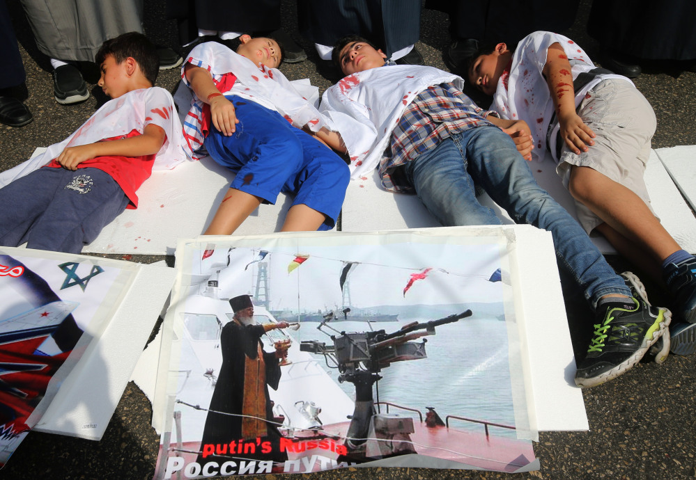 Lebanese boys depict Syrian boys who were killed by Russian airstrikes, during a sit-in in front the Russian embassy in Beirut, Lebanon, Wednesday.