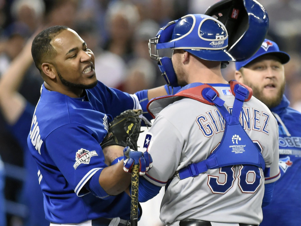 Toronto’s Edwin Encarnacion, left, is held by Texas Rangers catcher Chris Gimenez during an altercation as benches clear in the seventh inning. The benches cleared again after Troy Tulowitzki fouled out to end the inning.