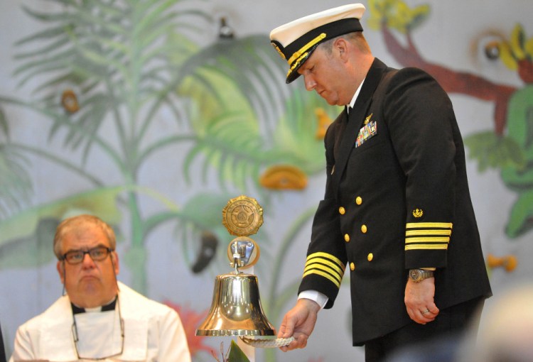 Chaplain Commander Clifford Stuart rings the bell for each life lost on the El Faro during a celebration of crew member Michael Holland’s life at the Jay Community Building on Wednesday.
