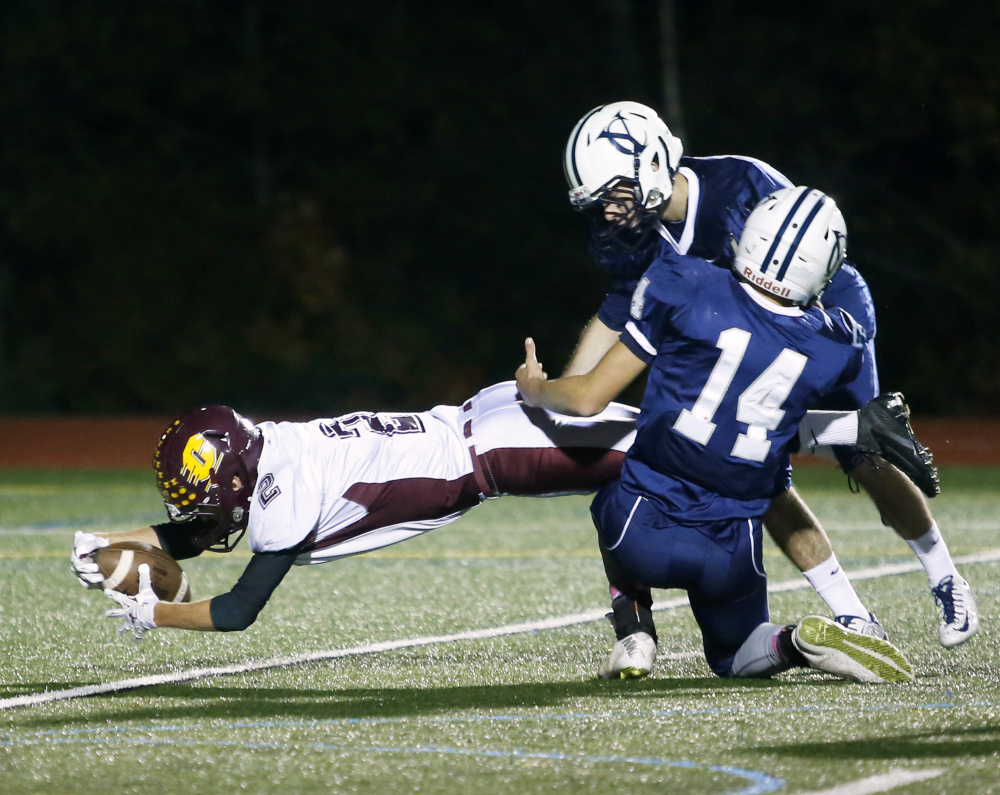 YARMOUTH, ME - OCTOBER 16: Cape Elizabeth at Yarmouth football. Nate Ingalls of Cape Elizabeth reaches to score a touchdown past Noah Eckersley-Ray (#14) and Remi Leblanc of Yarmouth. (Photo by Derek Davis/Staff Photographer)